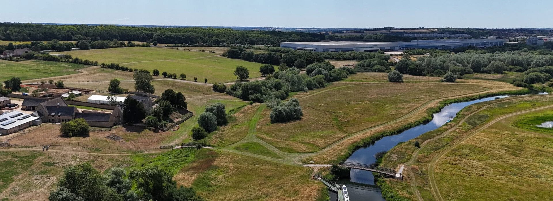 Aerial view of the RoseShire Festival grounds with lush fields and a winding river.